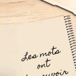 à côté d'un ordinateur, carnet avec la citation "Les mots ont du pouvoir"